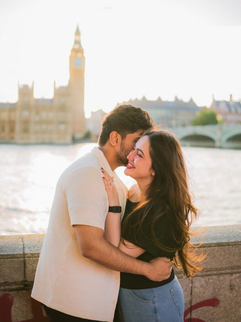 Couple embracing and smiling with Big Ben and London skyline in the background.