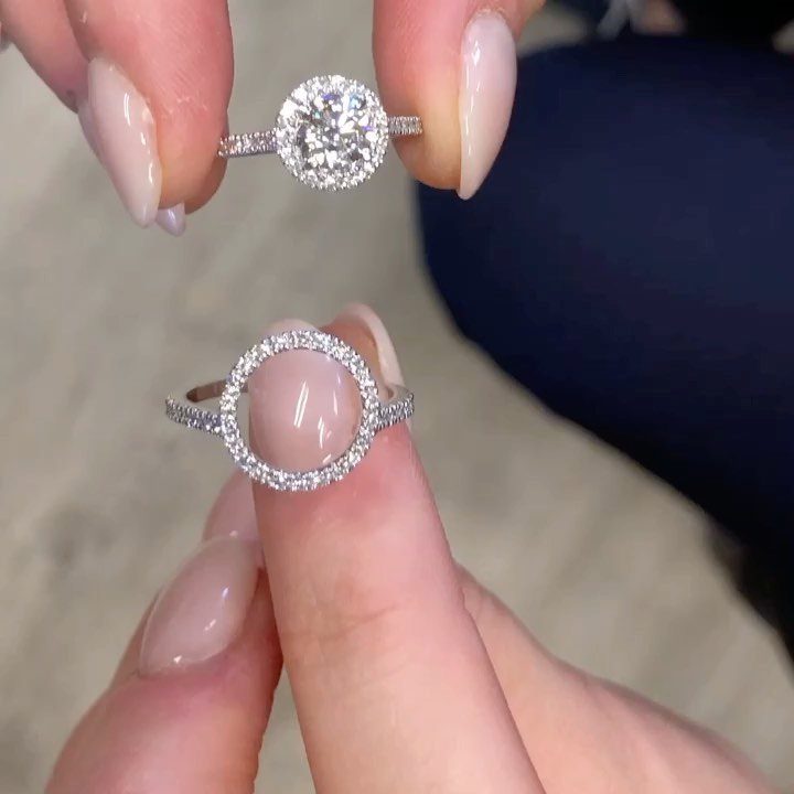 Two diamond wedding rings held by fingers with light pink manicured nails.