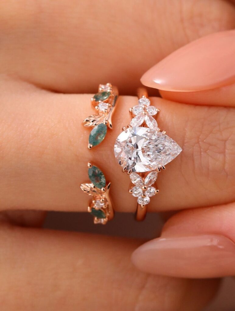 Rose gold wedding rings with a pear-shaped diamond and green emerald stones