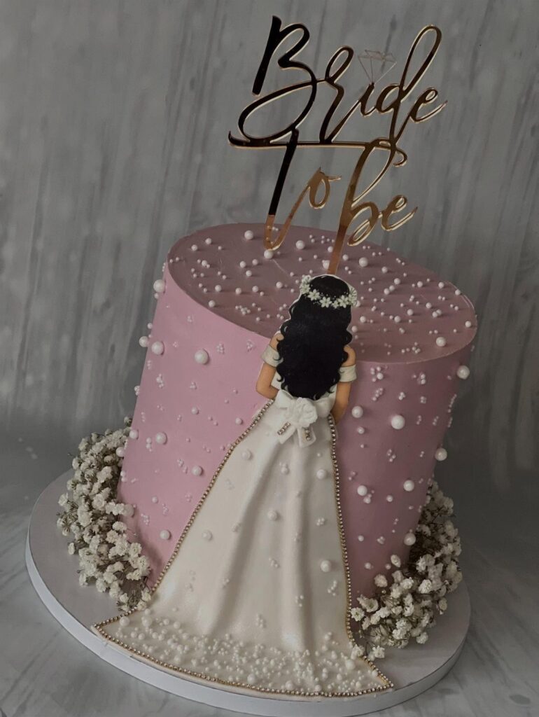 Pink bridal shower cake with a fondant bride and gold Bride To Be topper